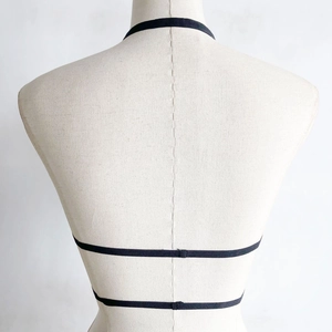 Dettaglio del reggiseno a gabbia nero con spalline multiple elastiche e scollo all'americana