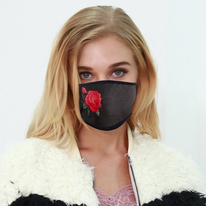 Close-up of red rose embroidery on a breathable black fabric mask for adults