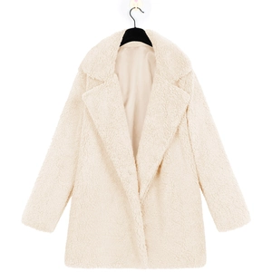 Close-up of fluffy cream teddy coat featuring lapel collar and soft faux fur texture