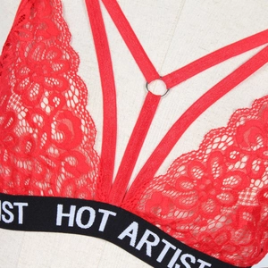 Detailed close-up of red lace bra with HOT ARTIST elastic band and crisscross straps