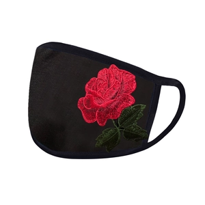 Detail showing red rose embroidery on breathable black fabric protective face mask
