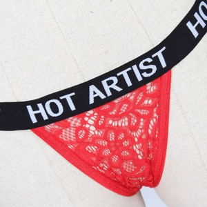Macro detail of red floral lace thong featuring a black Hot Artist elastic waistband