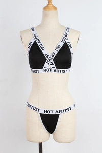 Close-up of the black elastic lingerie set featuring white HOT ARTIST letter straps