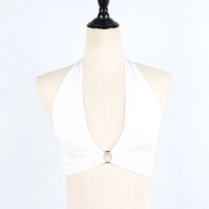 Détail d'un crop top blanc à licou avec anneau métallique central et décolleté en V profond