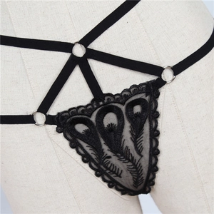 Détail de la broderie en dentelle noire et des anneaux sur ce string harnais