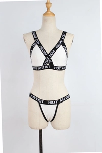Detail of cross-strap elastic band with HOT ARTIST lettering on white lingerie set