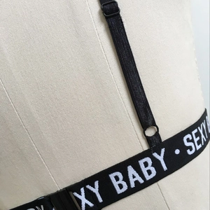 Détail de la sangle élastique noire réglable avec lettrage Sexy Baby et anneau en métal