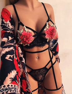 Détail d'un ensemble de lingerie en dentelle noire avec broderie pivoine et peignoir en soie