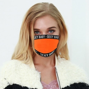Détail du masque respirant orange avec sangles noires et texte blanc sur le bord