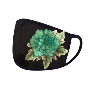 Close-up of green peony flower embroidery on a black breathable fabric protective mask