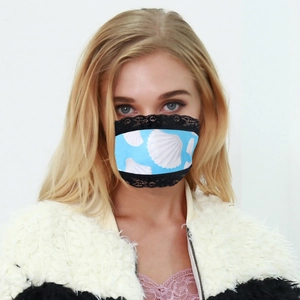 Detail of breathable lace face mask featuring blue shell pattern and black lace trim