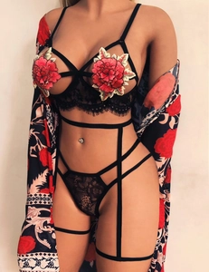 Détail de la broderie florale rouge sur lingerie en dentelle noire avec peignoir