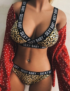 Detail showing leopard print lingerie with white SEXY BABY lettering on the black straps