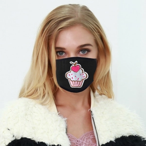 Close-up of black breathable fabric mask featuring a pink cupcake embroidery on a model
