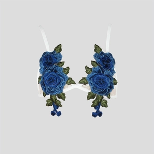 Detailed view of white lace bra featuring dark blue 3D rose embroidery and thin straps