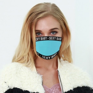 Détail du masque facial bleu clair avec bordure noire et impression de lettres blanches