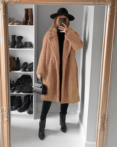 Detail of camel faux fur teddy coat featuring thick texture and notched lapels