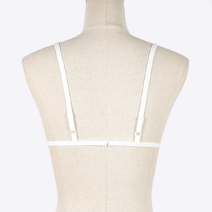 Detail view of white lace embroidered bra featuring ultra-thin straps and back buckle closure