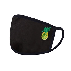 Detailed embroidery of a yellow pineapple on a breathable black fabric face mask