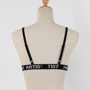 Detail of the back of a black bralette featuring a wide elastic band with HOT ARTIST text