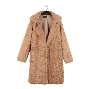 Detail of camel faux fur teddy coat featuring plush texture and wide lapel collar