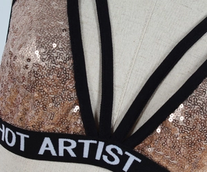 Close-up of rose gold sequins and elastic band with HOT ARTIST text on bralette