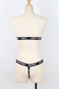 Detail view of white sequin lingerie set featuring black Hot Artist lettered straps