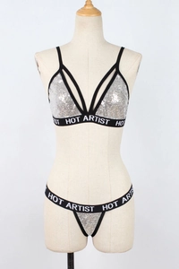 Detail of silver sequin lingerie set with HOT ARTIST lettering on elastic straps