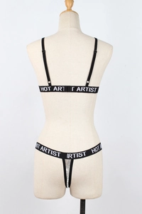 Close-up of black sequin lingerie set with HOT ARTIST lettered elastic straps
