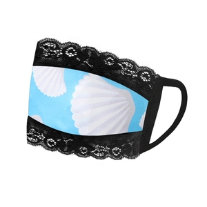 Close-up of light blue face mask featuring white shell patterns and black lace trim