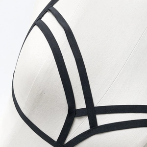 Detailed close-up of black elastic strappy body harness with geometric cutout design