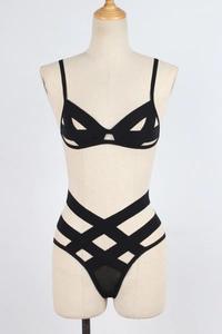 Detail view of black strappy lingerie set with elastic bandages and high-waist cutout design