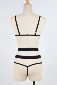 Back view of black strappy lingerie set with elastic harness design on a mannequin