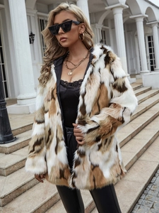 Detail of long hooded faux fur coat featuring white, brown, and black color-block patchwork