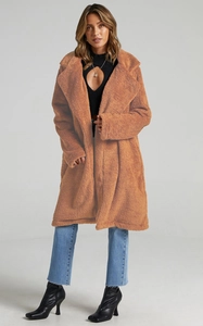 Close-up of oversized lapel and thick brown plush faux fur texture on teddy coat
