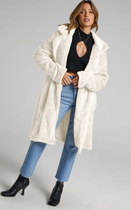 Detail of white oversized teddy fleece coat with wide lapels and textured lamb wool finish
