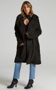 Detail of the oversized dark brown teddy faux fur coat with thick granular fleece texture