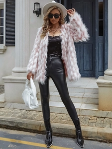 Manteau en fausse fourrure rose assorti à un pantalon en cuir noir et des bottes hautes