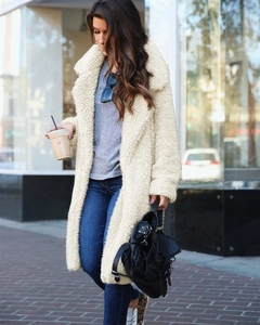 Detail of soft cream teddy coat showing textured faux fur fabric and oversized lapel