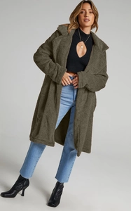 Full-length view of olive green faux lamb wool coat with oversized collar and plush texture