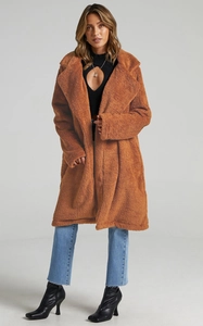 Long caramel teddy faux fur coat featuring oversized lapels and a thick plush texture for winter