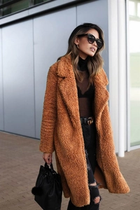 Detail of warm caramel teddy faux fur coat with large lapels and thick fuzzy texture