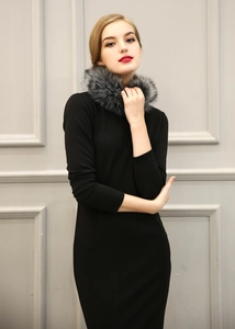 Détail d'une robe noire cintrée élégante avec un col orné de fausse fourrure luxueuse