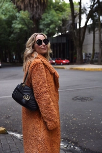 Close-up detail of caramel teddy faux fur coat texture and lapel collar design