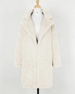 Detailed close-up of beige faux fur coat featuring a wide lapel and smooth texture