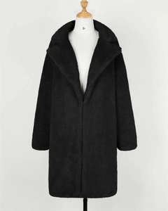 Detailed macro view of the thick black faux fur texture and lapel design on the coat