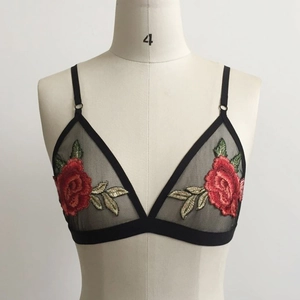 Detail view of black mesh triangle bra with delicate red rose floral embroidery