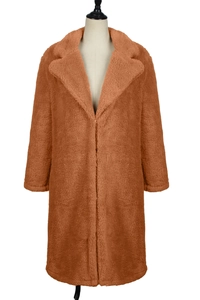 Detail of caramel faux fur teddy coat featuring a wide lapel and thick plush texture