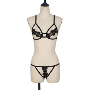Detail view of black lace lingerie set with strappy hollow-out bra on a mannequin