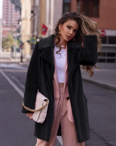 Close-up of black faux fur mid-length coat with large lapels and plush texture